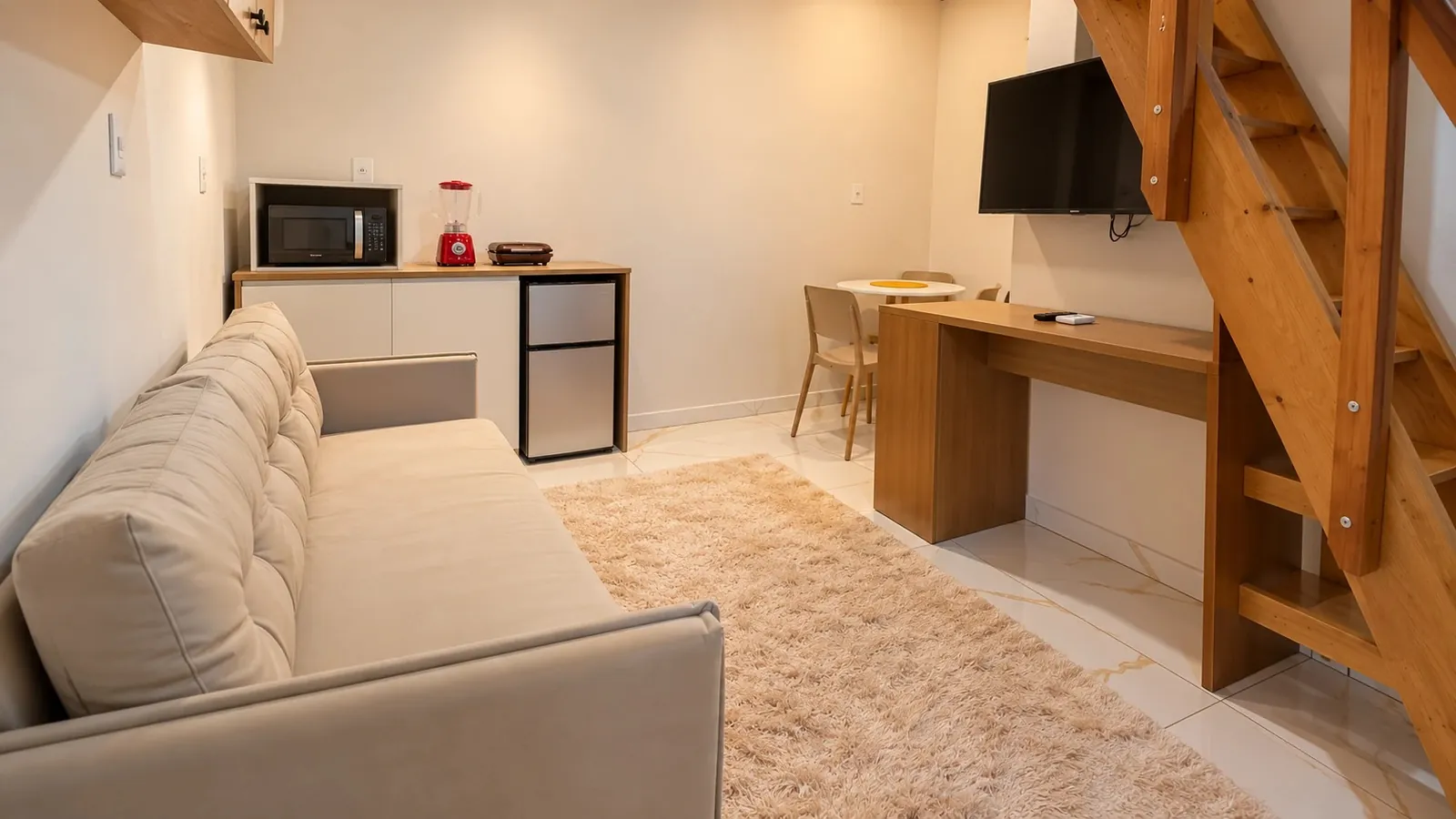 Studio 3 — sofa bed, kitchenette, desk and TV, stair on the right